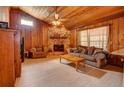 Living room with stone fireplace, wood paneled walls, and hardwood floors at 1220 Alden Ter, Deltona, FL 32738