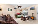 Living room with leather couches, wood floor, and large window at 1220 Alden Ter, Deltona, FL 32738