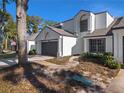 Two-story home with white exterior, dark garage door, and walkway at 252 Wimbledon Cir # 1702, Lake Mary, FL 32746