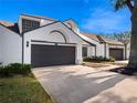 White two-story house with dark gray garage door and landscaping at 252 Wimbledon Cir # 1702, Lake Mary, FL 32746