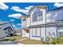 Two-story townhome with light beige siding, blue trim, and a manicured lawn at 2823 Boulder Falls Ct, Apopka, FL 32703