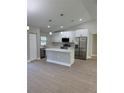 Modern kitchen with white cabinets, stainless steel appliances, and an island at 3 Fisher Loop Crse, Ocklawaha, FL 32179