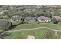 An aerial view showcases the property's location near a golf course, mature trees, and neighboring residences at 32604 View Haven Ln, Sorrento, FL 32776