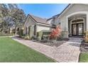 Charming home exterior features a tiled roof, manicured landscaping, and inviting brick walkway leading to the front door at 32604 View Haven Ln, Sorrento, FL 32776