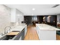 Open kitchen featuring a breakfast bar, marble countertops and backsplash, wood flooring, and stylish white cabinetry at 530 E Central Blvd # 603, Orlando, FL 32801