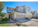 Two-story townhome with neutral siding, two-car garage, and landscaping at 5441 Leighton Ln, Oviedo, FL 32765