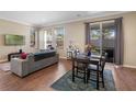 Living room with hardwood floors, gray sofa, and dining table at 5441 Leighton Ln, Oviedo, FL 32765