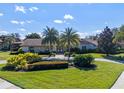 Charming home featuring a manicured lawn, lush landscaping, and elegant palm trees at 5737 Masters Blvd, Orlando, FL 32819