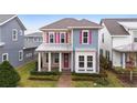 Two-story house with taupe and blue siding, pink shutters, and a covered porch at 8226 Nemours Pkwy, Orlando, FL 32827