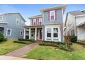 Two-story house with taupe and blue siding, pink shutters, and a covered porch at 8226 Nemours Pkwy, Orlando, FL 32827