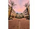 Exterior courtyard with palm trees, water fountain, and beautiful yellow condo buildings at 860 N Orange Ave # 163, Orlando, FL 32801