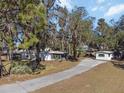 Two houses nestled on a large lot with mature trees and a curving driveway at 1016 W Lake Marion Rd, Haines City, FL 33844