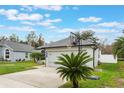 Gray house with a basketball hoop and palm tree at 1698 Riveredge Rd, Oviedo, FL 32766