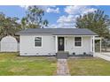 Newly renovated house with gray exterior, walkway, and a small shed at 1703 E Fern Rd, Lakeland, FL 33801