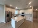 Modern kitchen featuring stainless steel appliances, a center island, and ample cabinet space at 2753 Redblush Ter, St Cloud, FL 34772