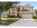 Two-story house with tan siding, brown accents, and a two-car garage at 2760 Curpin Ln, Orlando, FL 32825