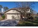 Two-story house with beige exterior, brick accents, and a two-car garage at 3511 Exeter Ct, Orlando, FL 32812