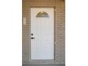 White front door with a half-moon window and brick surround at 355 E Hoffman St, Lake Alfred, FL 33850