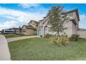 Two-story house on a tree-lined street with a landscaped lawn and paved driveway at 4457 Lions Gate Ave, Clermont, FL 34711