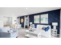 Living room with white couch, blue accent wall, and adjacent dining area at 4823 Cranberry Way, Lakeland, FL 33811