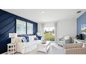 Living room with white couch and blue accent wall; view of backyard at 4823 Cranberry Way, Lakeland, FL 33811