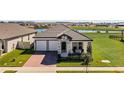 One-story house with a two-car garage and a view of a lake at 5157 Citrus Leaf Blvd, Winter Garden, FL 34787