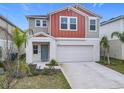 Two-story house with gray and burnt orange siding, two-car garage, and landscaping at 5381 Maddie Dr, Haines City, FL 33844