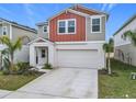 Two-story house with gray and burnt orange siding, two-car garage, and landscaping at 5381 Maddie Dr, Haines City, FL 33844