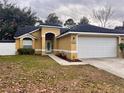 Front view of a house with a two-car garage and spacious yard at 1073 Kelly Creek Cir, Oviedo, FL 32765