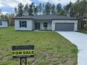 Inviting single-story home with a 'For Sale' sign on a lush green lawn at 13188 Sw Sw 65Th Cir, Ocala, FL 34473