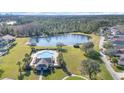 Community pool and clubhouse with a pond and lush green space at 14457 Jamaica Dogwood Dr, Orlando, FL 32828