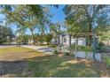 Landscaped front yard with a pergola and mature trees at 2061 Petit Ct, Apopka, FL 32712