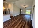 Bright living room featuring hardwood floors, vaulted ceilings, and a window with a view to the lush yard at 238 Locust Rd, Ocala, FL 34472
