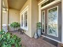 Inviting front porch with brick flooring, potted plants, and a double door entry at 250 Bayou Bend Rd, Groveland, FL 34736