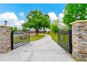 Ornate black metal gate opens to a long driveway leading to a home at 3401 Abalone Blvd, Orlando, FL 32833