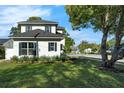 An attractive home with black shutters, surrounded by vibrant green grass and healthy plants at 500 W Hazel St, Orlando, FL 32804
