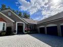Brick house with a three-car garage and paver driveway at 5001 Latrobe Dr, Windermere, FL 34786