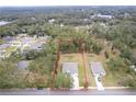 Aerial view of two houses on a lot, surrounded by trees and other houses at 606 Urick St, Fruitland Park, FL 34731