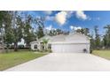 Single story house with a three-car garage and lush green lawn at 606 Urick St, Fruitland Park, FL 34731