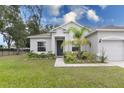 Single story home with gray exterior, landscaping, and two car garage at 606 Urick St, Fruitland Park, FL 34731