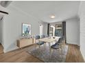 Modern dining room with light wood table, stylish chairs, gray rug, and a sliding glass door at 67 Sabal Cay Court, New Smyrna Beach, FL 32169