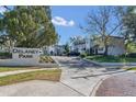 Entrance to Delaney Park apartment community with landscaping and brick driveway at 801 Weldona Ln # 201, Orlando, FL 32801