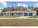 Ranch style home with gray exterior, two-car garage, and landscaped yard at 851 Marllo Rd, Kissimmee, FL 34744