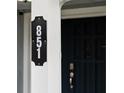 Modern house number sign on a white column next to a dark door at 851 Marllo Rd, Kissimmee, FL 34744