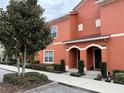 Orange two-story building with two entrances and landscaping at 8956 California Palm Rd, Kissimmee, FL 34747