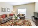 Living room with gray couches, coffee table, and patterned rug at 8956 California Palm Rd, Kissimmee, FL 34747