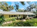 House exterior showcasing a large covered patio and lush greenery at 1115 Lake Nettie Dr Dr, Eustis, FL 32726