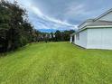 Side view of the house showing a large backyard and surrounding landscape at 1445 Olympic Club Blvd, Champions Gate, FL 33896