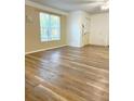 Spacious living room with wood-look floors and bright natural light streaming through the window at 1606 Lime St, Kissimmee, FL 34746