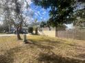Single story home with side yard and wooden fence at 1606 Lime St, Kissimmee, FL 34746